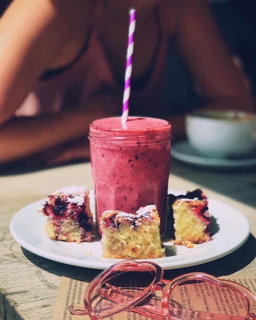 Photo close-up of drink and dessert in plate on table