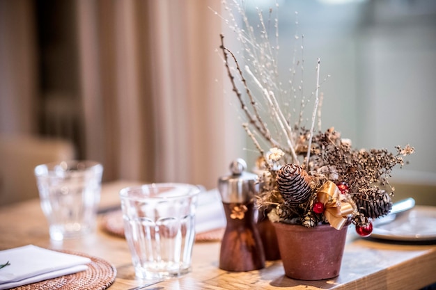 Close up of drinking glasses and Christmas decorations on wooden dining table