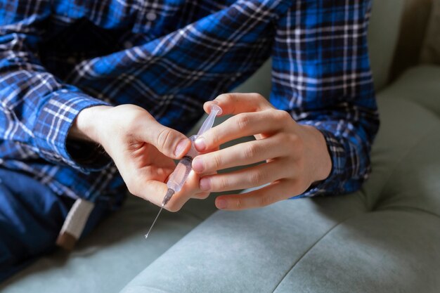 A close up drug addicted person holding a syrenge going to have a dose