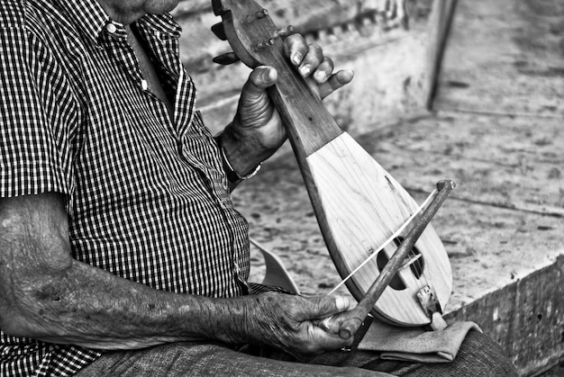 Close up of elderly man playing some traditional instrument