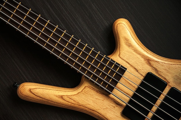 Close up of electric bass guitar with five strings Musical instrument on dark background