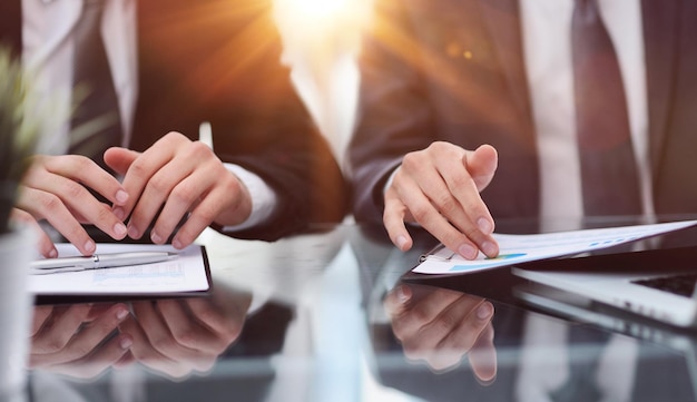 Close up of employees discuss financial paperwork at meeting