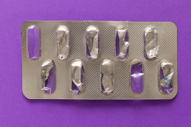 Photo close-up of empty blister pack over colored background