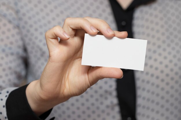 Close-up of an empty business card in a woman's hand.