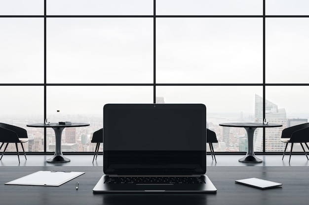 Close up of empty laptop screen on gray office desktop with supplies on panoramic window and city view background Mock up 3D Rendering