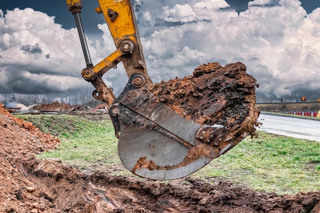 Close up of excavator bucket at construction site The excavator is digging a trench for underground utilities Construction equipment for earthworks