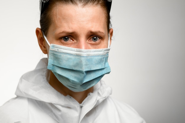 Close-up. Face of girl in medical mask with sad expression.