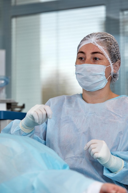 Close up of the face of a patient who is undergoing blepharoplasty The surgeon cuts the eyelid and performs manipulations using medical instruments