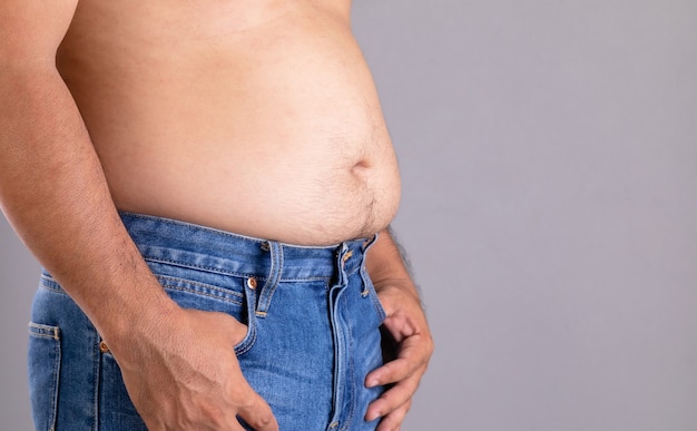 Close up fat man standing and show his tummy with. Fat people and healthy concept