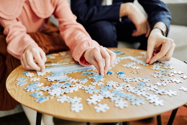 Close up of father and daughter playing puzzle game together at home copy space