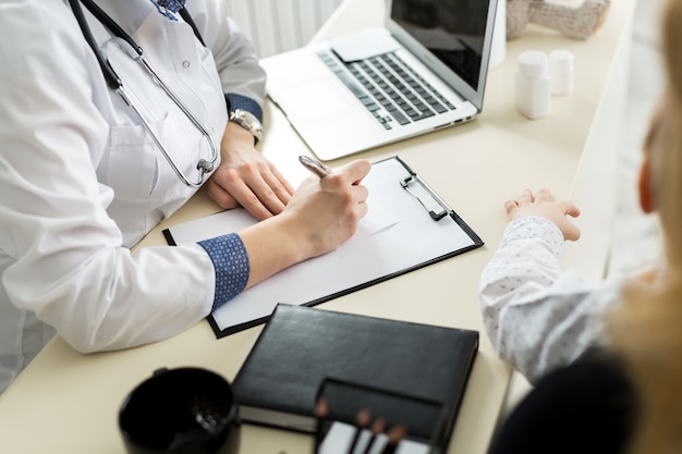 Close-up Of Female Doctor Filling The Medical Form