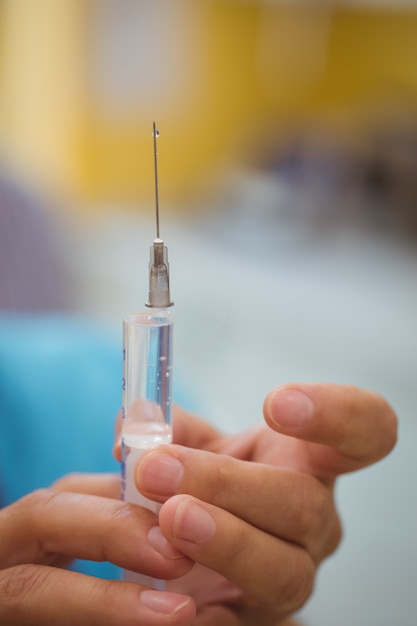 Close-up of female doctor holding an injection