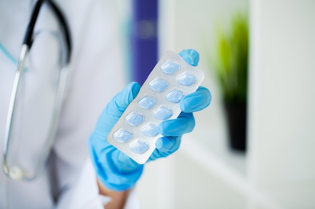 Close up of female doctor holding pill for men health