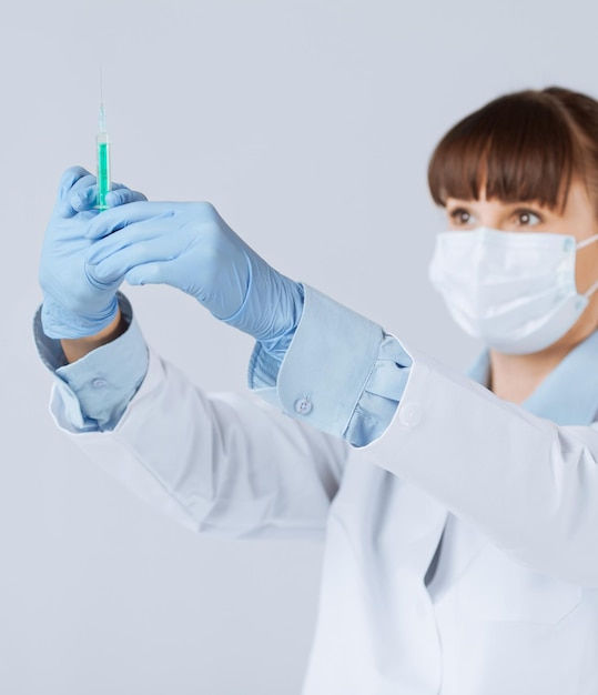 close up of female doctor holding syringe with injection