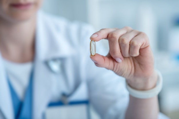 Close up of a female hand holding a pill