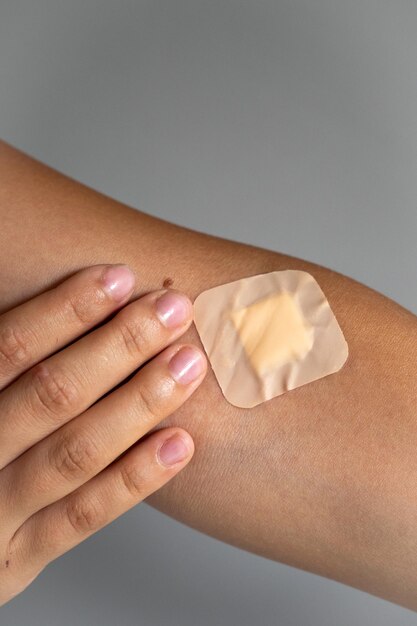 Photo close up of female hand with a band-aid glued, gray background with copy space. blood donor concept. high quality photo