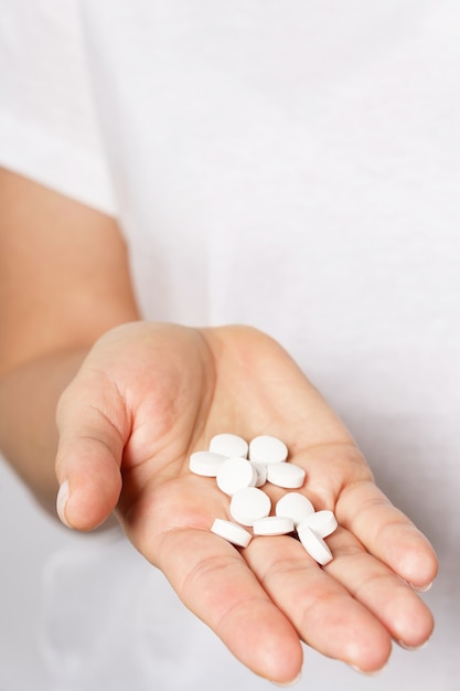 Close up of female hand with a handful of pills