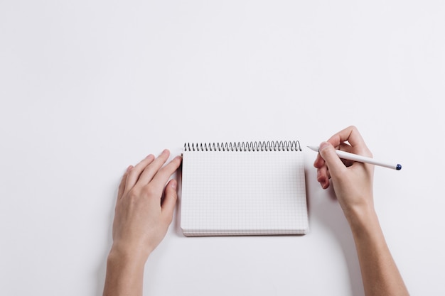 Close-up of female hand writing pen in a blank notebook