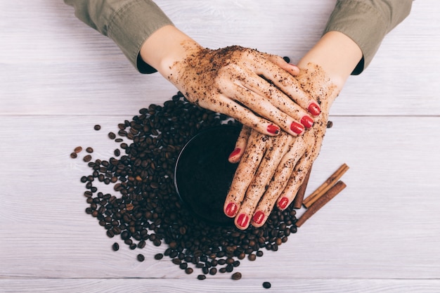 Close-up of female hands apply coffee scrub