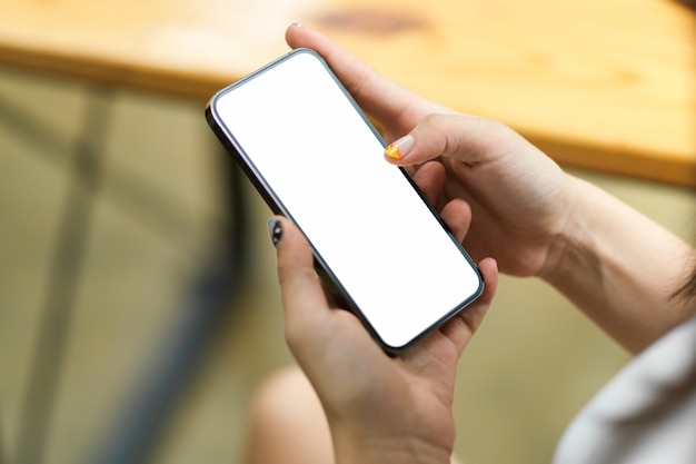 close up of female hands browsing using paying holding on smartphone with blank screen