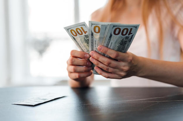 Photo close up of female hands counting dollar banknotes