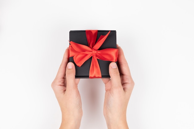 Close up of female hands holding christmas gift over white background. High quality photo