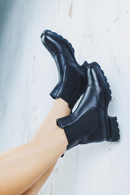 Close up of female legs in black leather Chelsea boots New autumn collection of women's leather shoes 2022