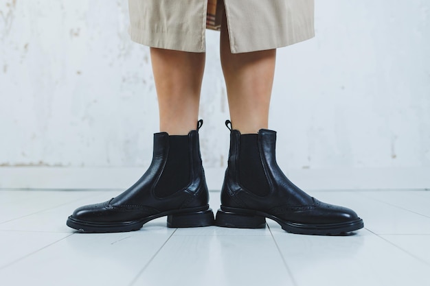 Close up of female legs in black leather Chelsea boots New autumn collection of women's leather shoes 2022