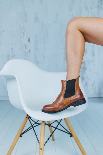 Close up of female legs in brown leather Chelsea boots New autumn collection of women's leather shoes 2022