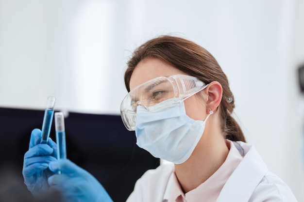 Close up. female scientist looking at liquid in test tubes. science and health.