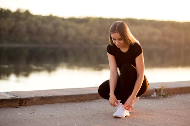 Close up of female sport fitness runner getting ready for jogging outdoors