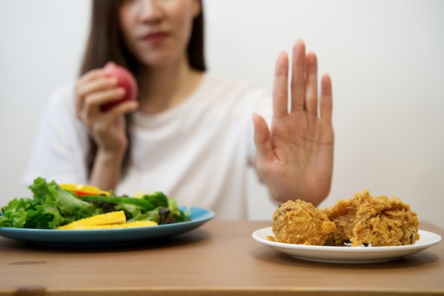 Close up female using hand reject junk food by pushing out her favorite fried chicken.