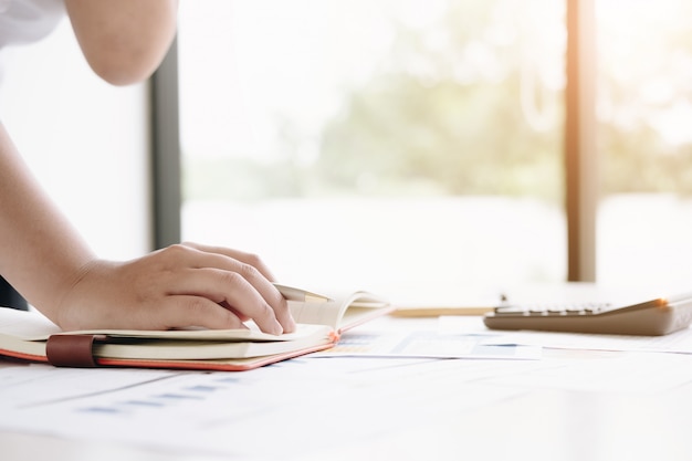 Close up financial inspector hands making report, calculating or checking balance. 