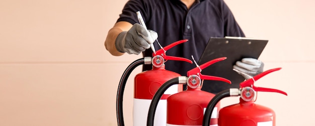 Close up fire extinguisher and firefighter checking pressure gauge level for protection and prevent and safety rescue and use of equipment on fire training concept