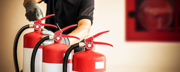 Close up fire extinguisher and firefighter checking pressure gauge level