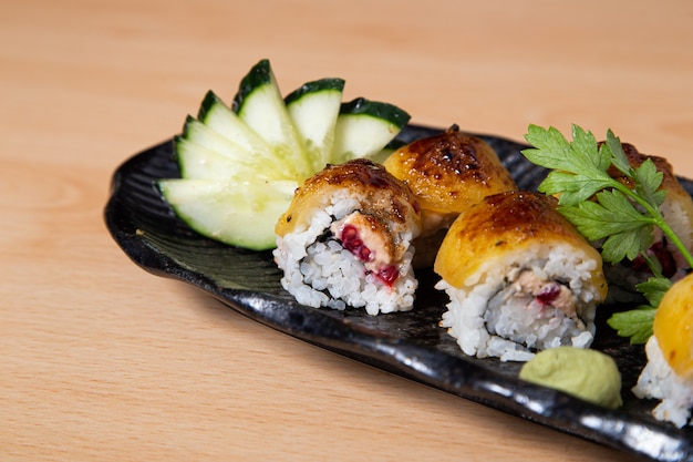 Close-up of flambÃÂÃÂ© maki roll stuffed with octopus on wooden background