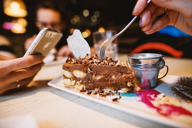 Close up focus view of desert chocolate cake with cute small milk can on the plate in a restaurant.