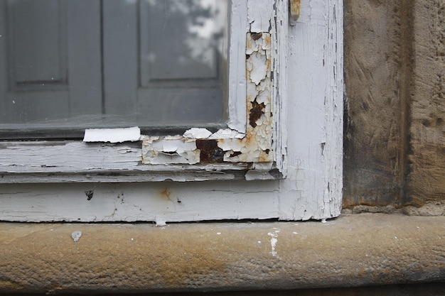 a close up of a fragment of an old window with a paint peeling off