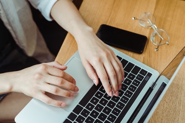 Close up freelancer woman using computer and working on project at home