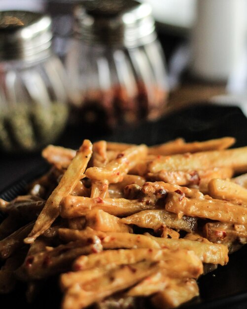 Photo close-up of french fries in plate on table