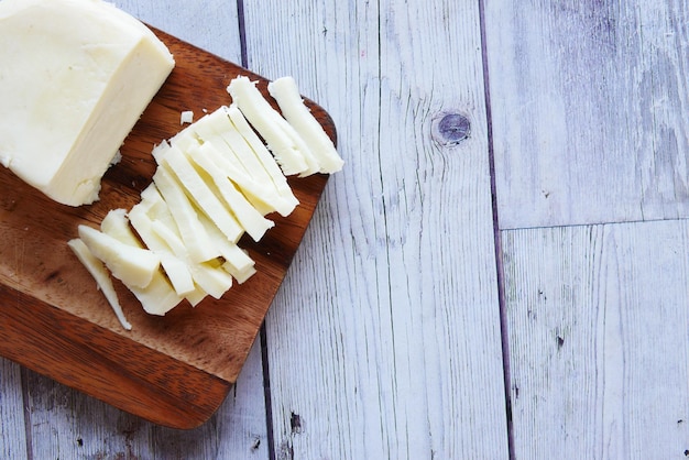 Close up of fresh cheese on a chopping board on table