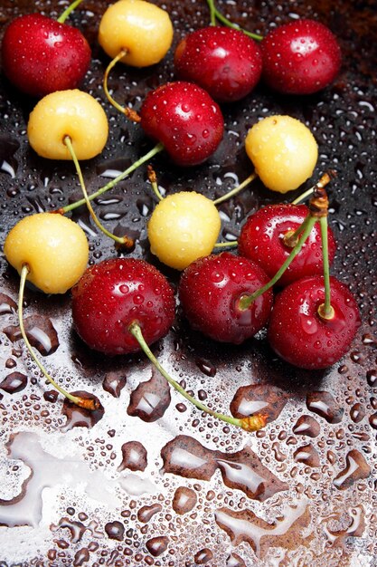 Close up of fresh cherry berries with water drops Composition of sweet cherries on a dark background with water drops top view