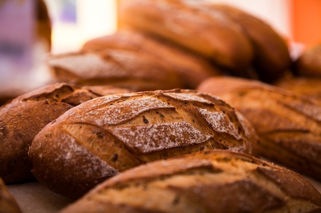 Close-up of fresh white bread in rolls stands in even rows in a bakery