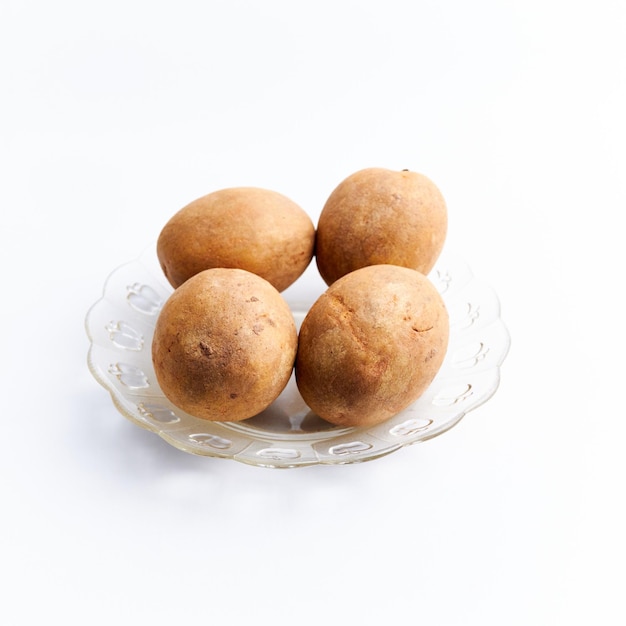 Close-up of fresh whole sapodilla fruit ready to eat isolated on white background