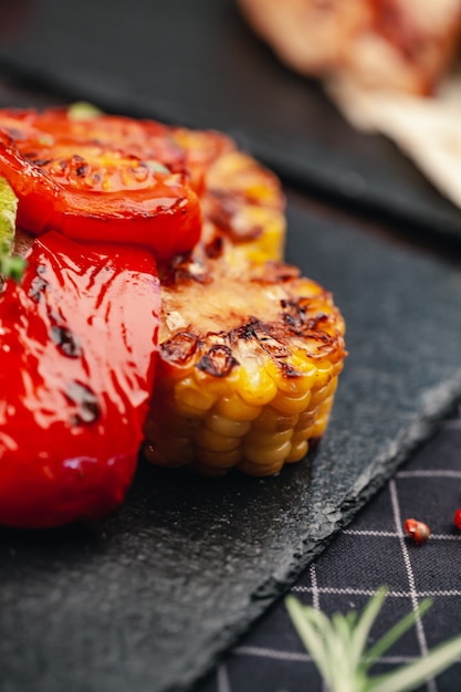 Close up freshly grilled on wood tomatoes and corn