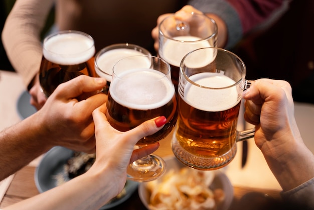 Close-up friends holding beer mugs