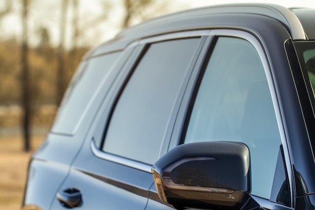 Close up front view of car side mirror. Front rear view mirror on the car window. Car exterior details.