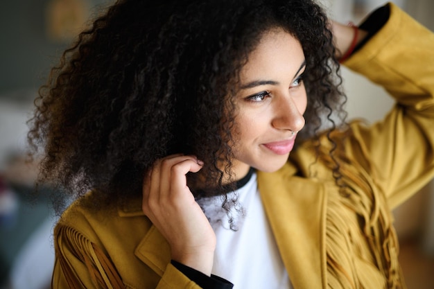 Close-up front view portrait of beautiful young woman indoors, standing.