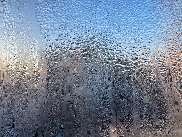 a close up of a frosted window with a blue sky in the background