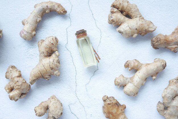 Close up of gingers and oil in a small container on table